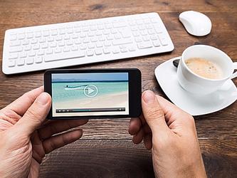 Person watching video on mobile phone_Crop